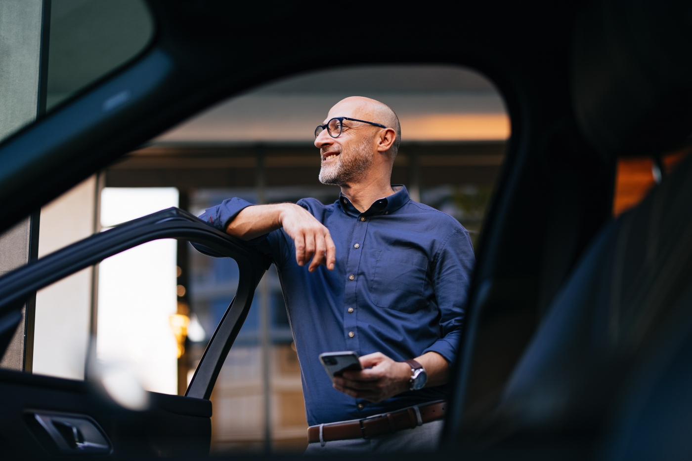 man smiling next to a car
