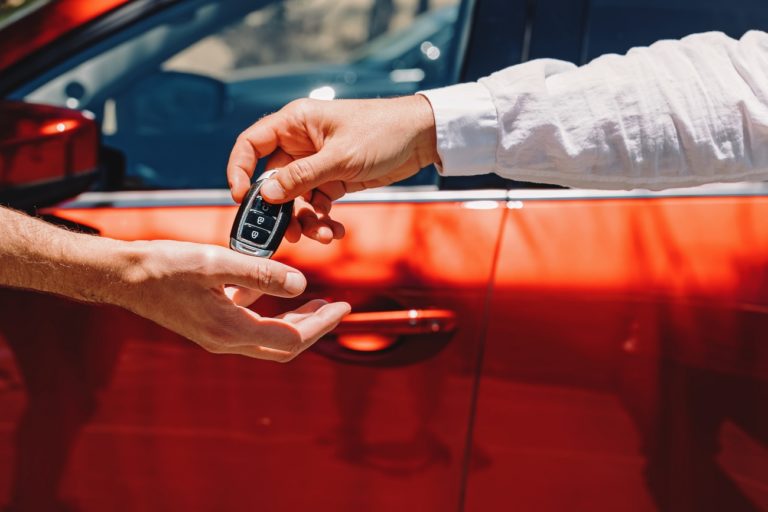 man passing car keys over to someone else
