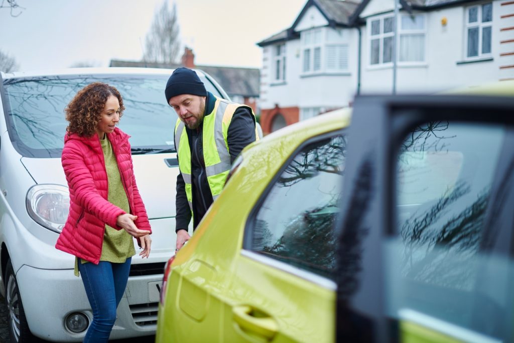 woman pointing out damage to her car